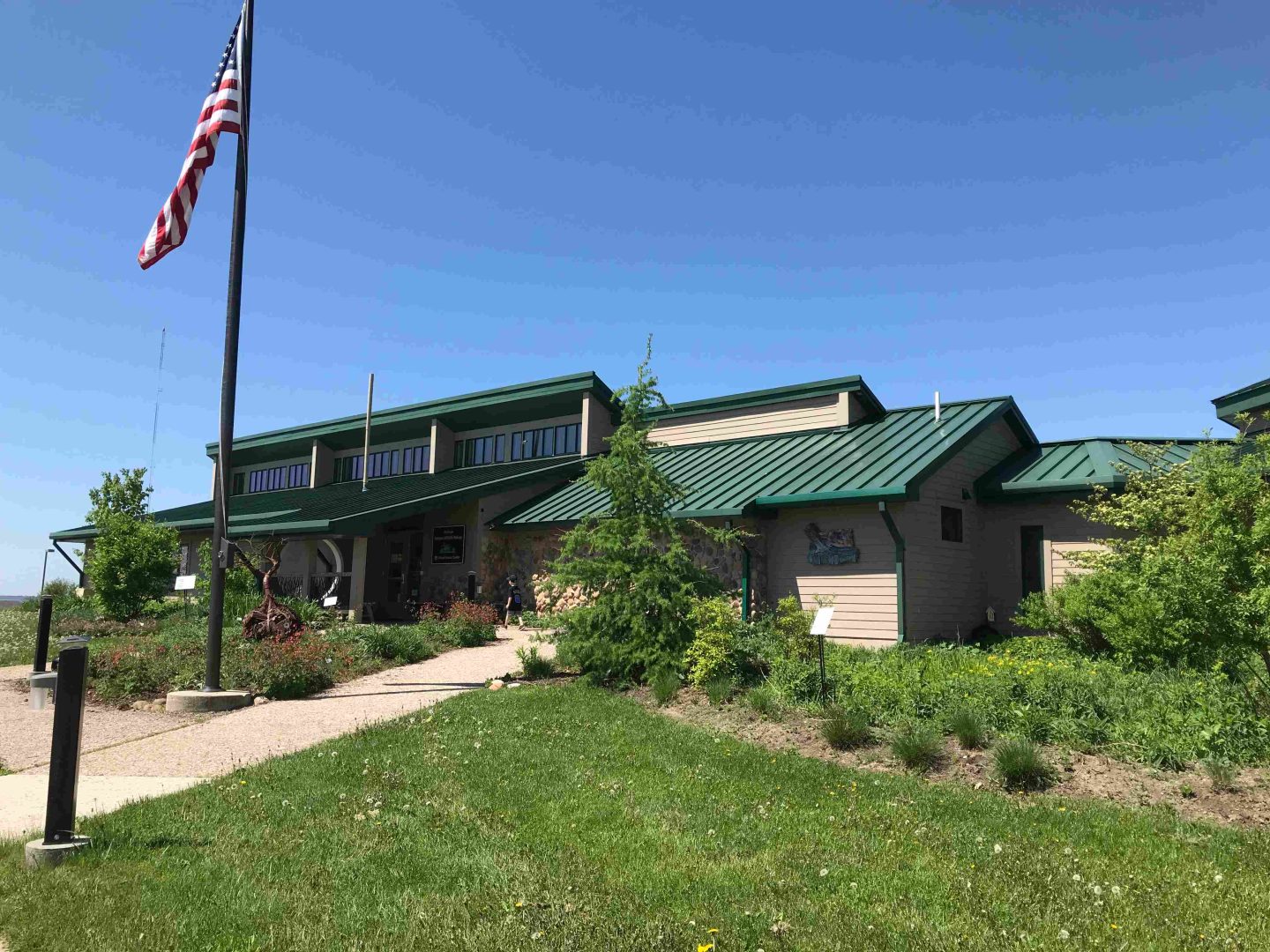 Horicon National Wildlife Refuge Visitor Center with American flag on flag pole and blue skies in the background