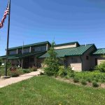 Horicon National Wildlife Refuge Visitor Center with American flag on flag pole and blue skies in the background