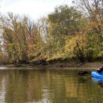Kayaker paddling on the Rock River in Dodge County WI in fall