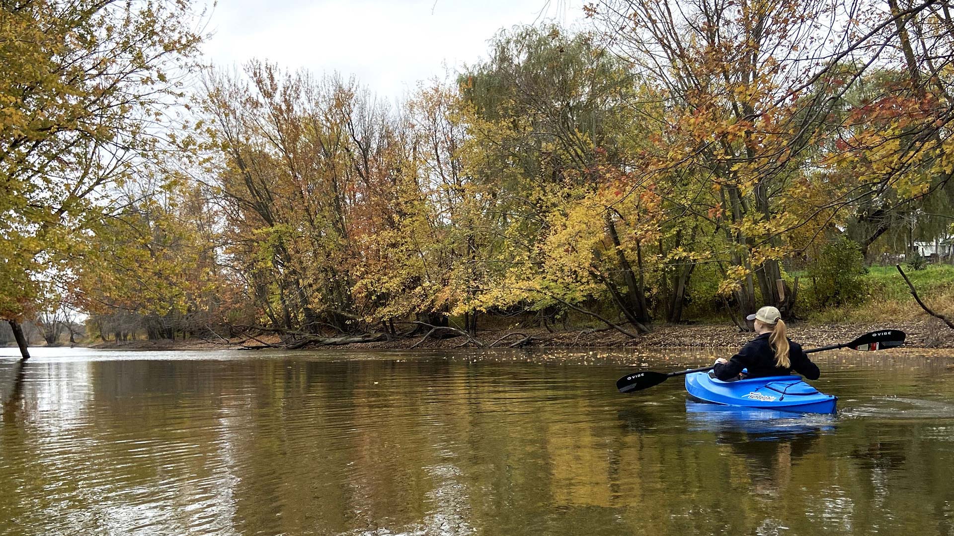 Kayaker paddling on the Rock River in Dodge County WI in fall